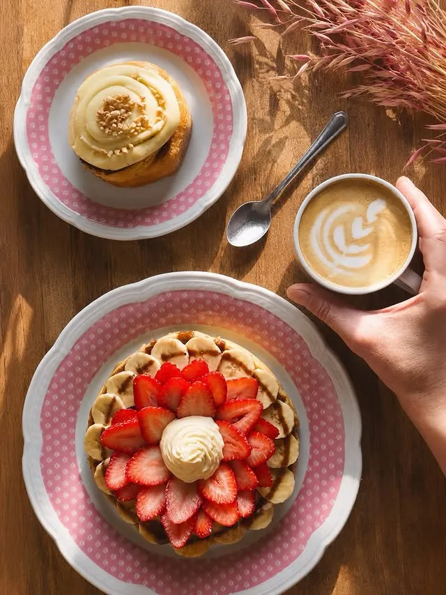 Waffle con frutillas, roll de canela y café